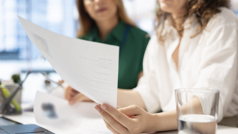 Two people looking at pieces of paper