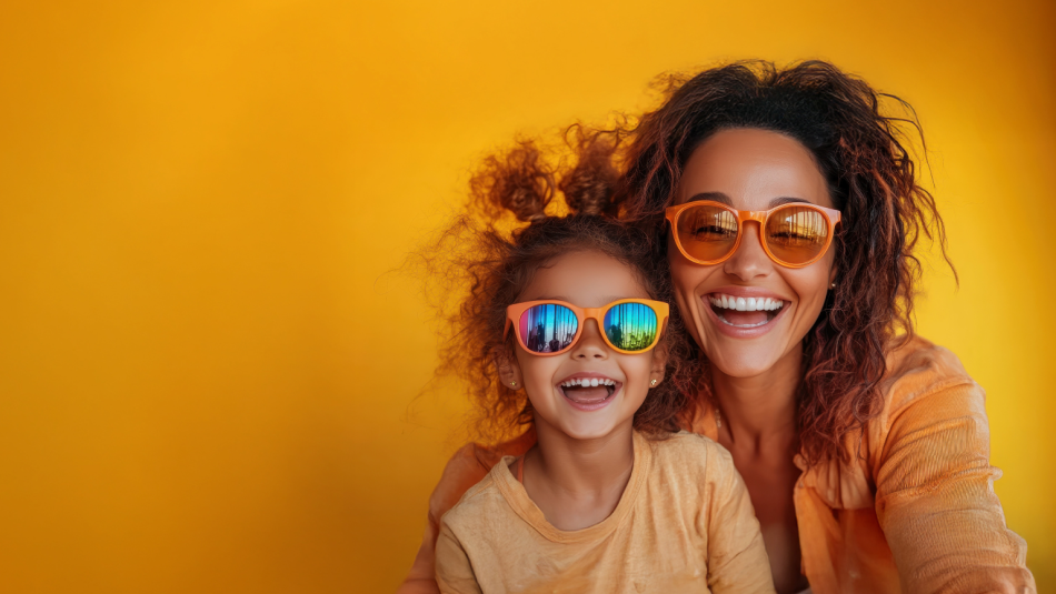 Mother and daughter wearing sunglasses against a bright yellow background